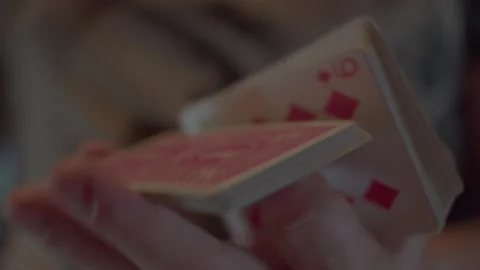 Man's hands are shuffling a deck of cards with a red back Stock Footage 197387781