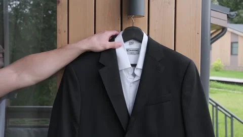  man's hands are taking a suit off a hanger. Stock-Footage 318163316