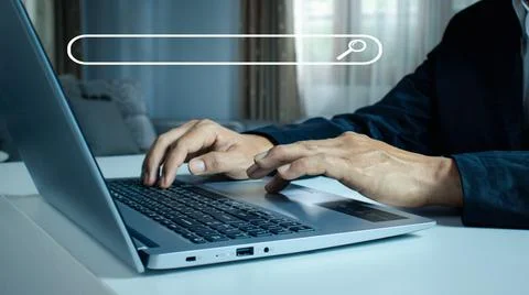 Man's hands are using a computer notebook to Searching for information. Stock Photos