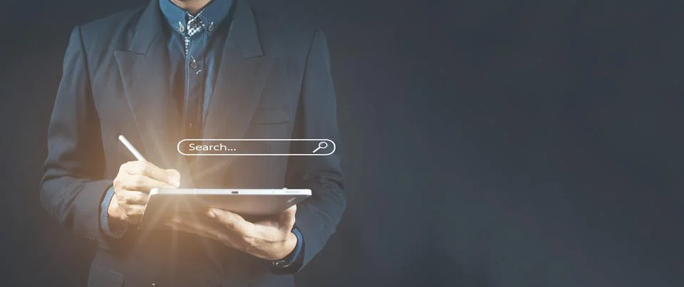 Man's hands are using a computer notebook to Searching for information. Stock Photos