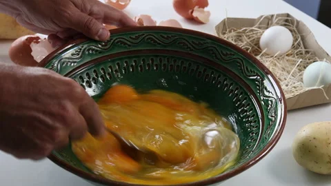 Man's hands beating eggs to prepare a Spanish omelette Stock Footage 197117517