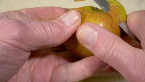 Man's hands beginning to peel an apple with a small knife. Stock-Footage 154740182