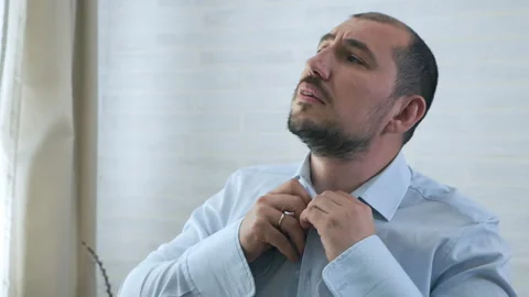 Man's hands buttoning a white shirt. Man with a beard dressing wear clothes for Stock Footage 115978692