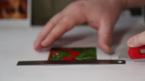 The man's hands carefully cut out a magnet with a knife. Stock Footage 282730703