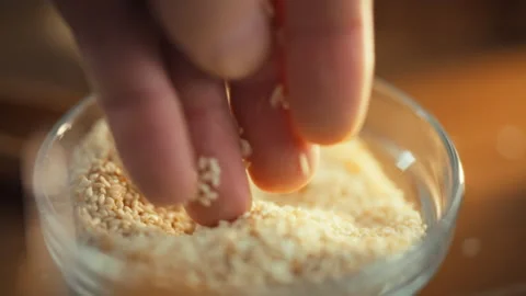 A mans hands carefully inspect sesame grains pouring them into a bowl as the Stock Footage 331310345