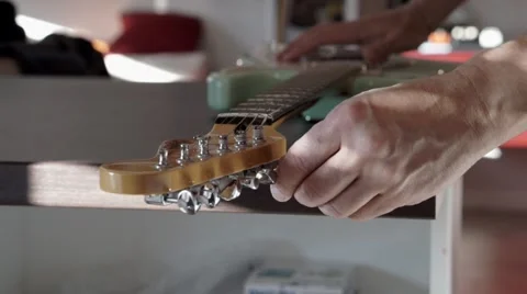 Man's hands changing strings on his  electric guitar Stock Footage 44829675
