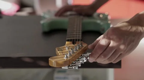 Man's hands changing strings on his  electric guitar Stock Footage 44829737