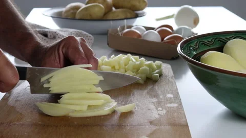Man's hands chopping potatoes to prepare a Spanish omelette. Video stock 197118077