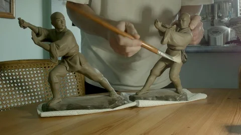 Mans hands cleaning ceramic Chinese Kung Fu ornaments. Color corrected version. Vidéo 72955069