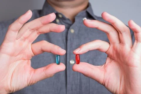 Man's hands close-up holding red and blue pills Stock Photos
