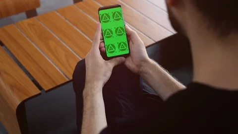 Man's Hands Close Up of Phone With Green Screen with Wooden Table Background Stock Footage 109604605