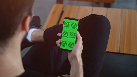 Man's Hands Close Up of Phone With Green Screen with Wooden Table Background Stock Footage 109604614