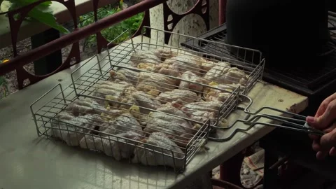 Man's hands closes the grate and puts a grill with chicken on mangal. Stock Footage 169151475