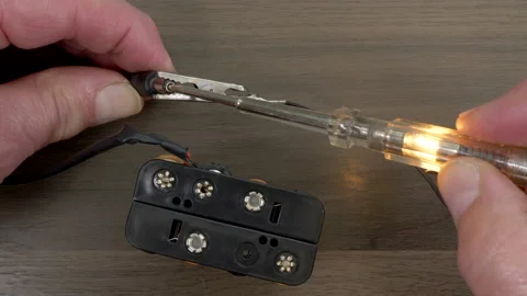 Man’s hands connecting a test lamp to check a 12 volt battery power source. Stock Footage 155963083