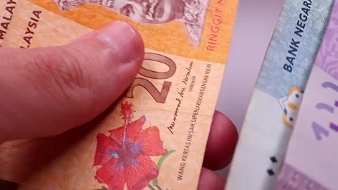 Man's hands counting brand new Malaysian ringgit (MYR). Close up view. Stock-Footage 296429402