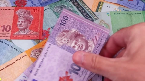 Mans hands counting brand new Malaysian ringgit (MYR) banknotes. Stock Footage 300050985