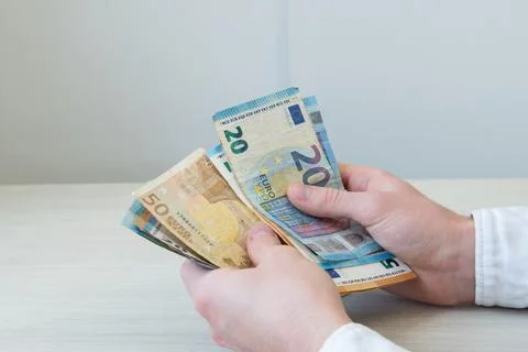 A man's hands counting a stack of euro banknotes. Successful business deals Stock Photos