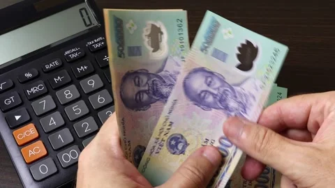 Man's hands counting Vietnamese dong (VND) cash money banknotes. Stock Footage 303580779