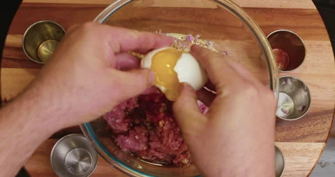 Man's hands cracking an egg and mixing lean ground turkey. Stock Footage 130690349