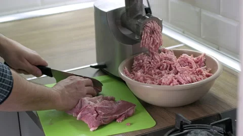 Mans hands cut raw meat with the knife in the kitchen. Preparation of minced Stock Footage 165373012