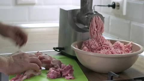 Mans hands cut raw meat with the knife in the kitchen. Preparation of homemade Video stock 165787725