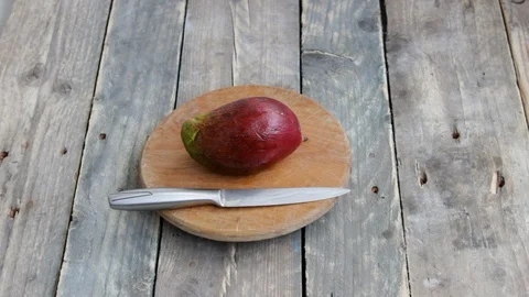 Man`s hands cuts mango half cut into the cubes on the wooden background Stock Footage 129625984
