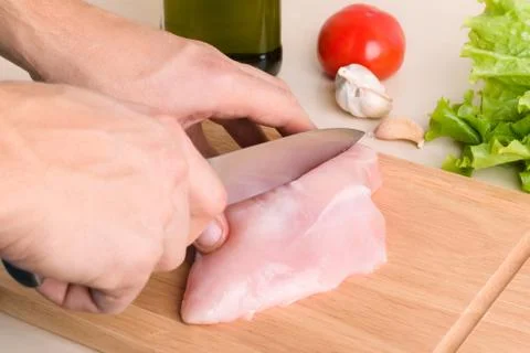 Man's hands cutting chicken Stock Photos