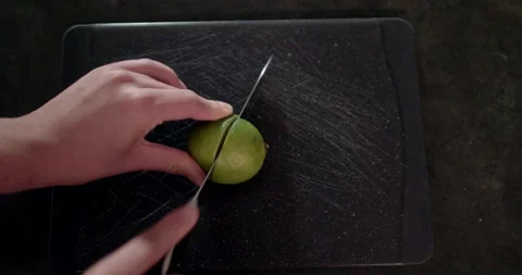 Man's hands cutting citrus fruit on a chopping board Stock Footage 238775418
