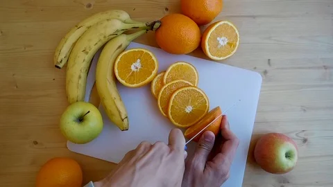 Man's hands cutting fresh orange Stock Footage 106469739
