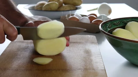 Man's hands cutting potatoes to prepare a Spanish omelette. Stock Footage 197118011