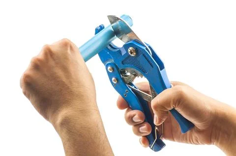 Man's hands cutting pvc pipe, hand tool, isolated over white. Stock Photos