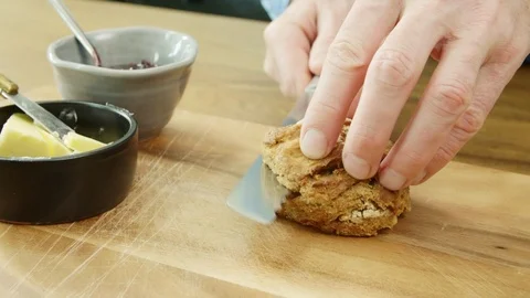 Man's Hands Cutting Scone And Spreading Butter With Knife Stock Footage 86072462