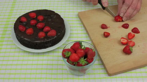 Mans hands decorating a chocolate fudge cake with strawberrys Stock Footage 63307744