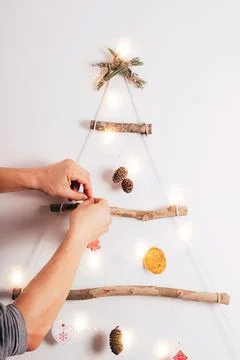 Man's hands decorating Christmas tree on white background. Stock Photos