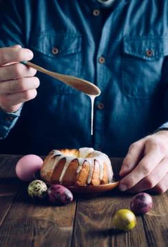 Man's hands decorating traditional Easter ring cake Stock Photos