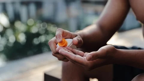 Man's hands dispensing sunblock from a bottle, preparing skin for sun protection Stock Footage 328160015