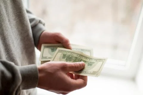 Man's hands with dollars on white background. man gives a bribe . corruption  Stock Photos