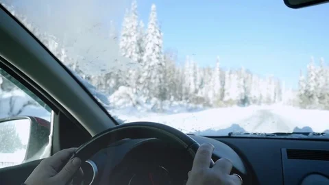 Man's hands of a driver on steering wheel on winter landscape outdoors in slow Stock Footage 70357494