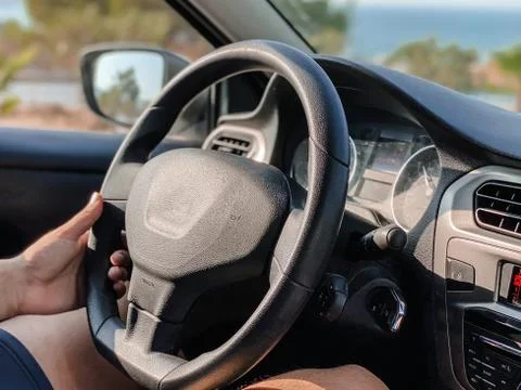 Man's hands driving a car while driving. Travel concept. Stock Photos