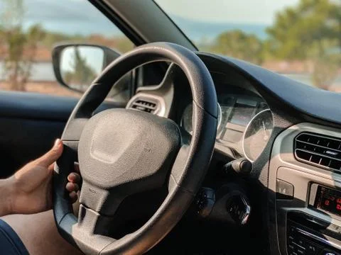 Man's hands driving a car while driving. Travel concept. Stock Photos