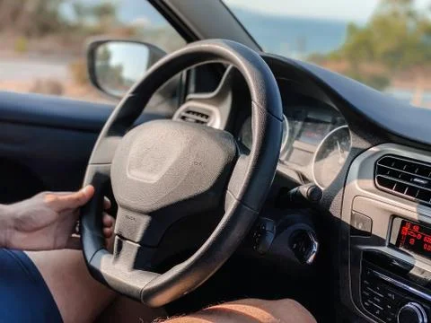 Man's hands driving a car while driving. Travel concept. Stock Photos