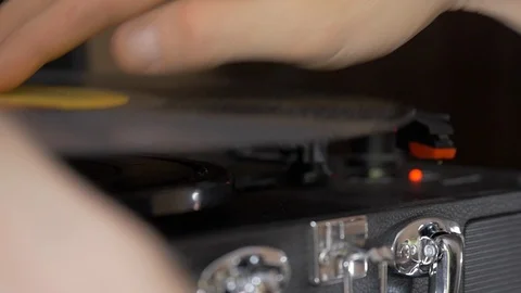 A man's hands drop a needle onto a record player. Video stock 100650273