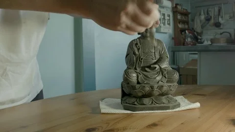 Mans hands dusting a ceramic buddha ornament. Color corrected version. Stock Footage 72966999