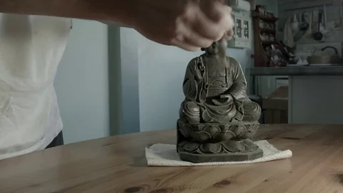 Mans hands dusting a ceramic buddha ornament. Not B&amp;W Stock Footage 72967023