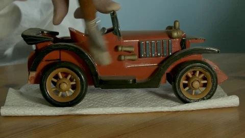 Mans hands dusting a red antique model car. Color corrected version. Stock Footage 72970634