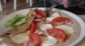 man's hands eat savoury pancake with cheese tomato, cucumber and ham HD Footage