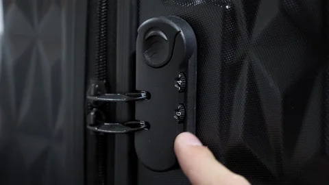 Man's hands enter password on suitcase combination lock on the suitcase. Stock Footage 111018725