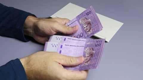 Man's hands, envelope and Malaysian ringgit (MYR) cash money banknotes. Stock Footage 303371372