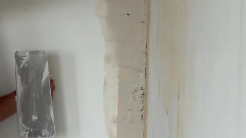 Man's hands finishing a drywall joint with plaster Vídeos de archivo 341362846