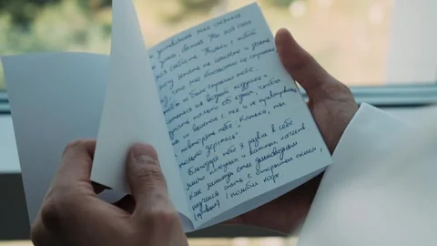 A man's hands flip through a notebook with handwritten notes Stock Footage 309498306